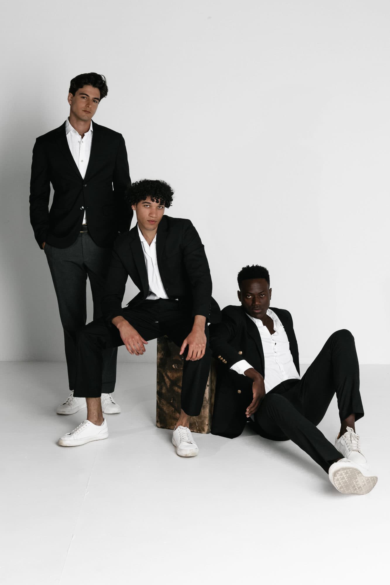 Male talent group in black suits at a studio shoot