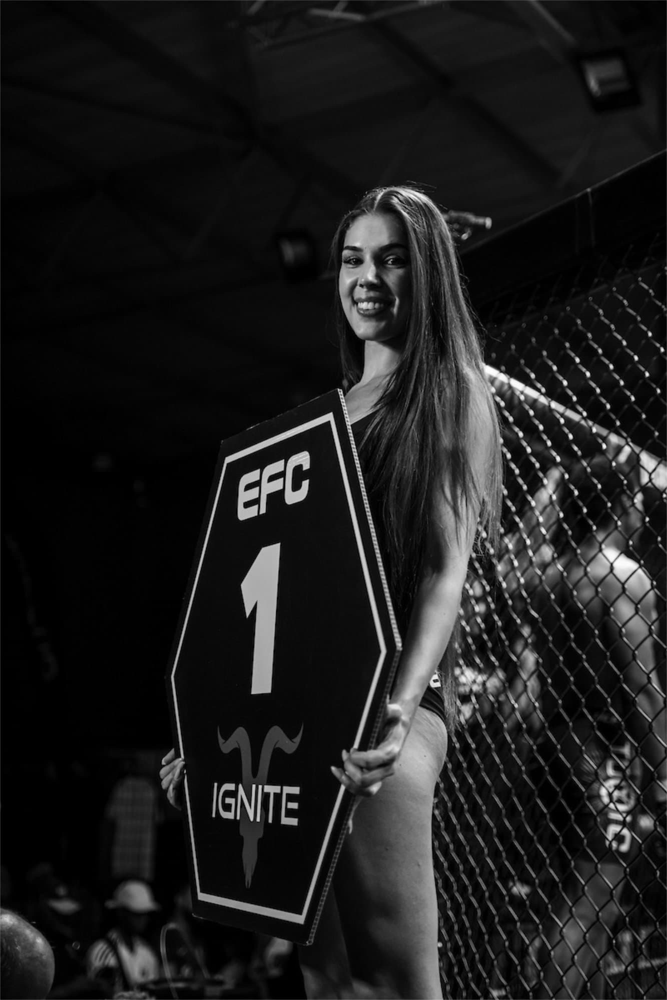 EFC ring girl with round card by the octagon fence