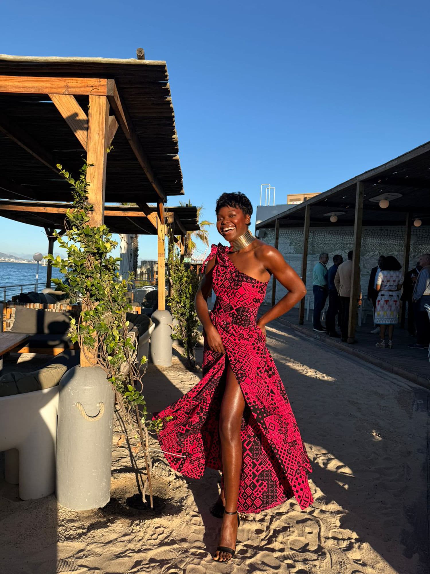 Performer in red African dress at a beach venue