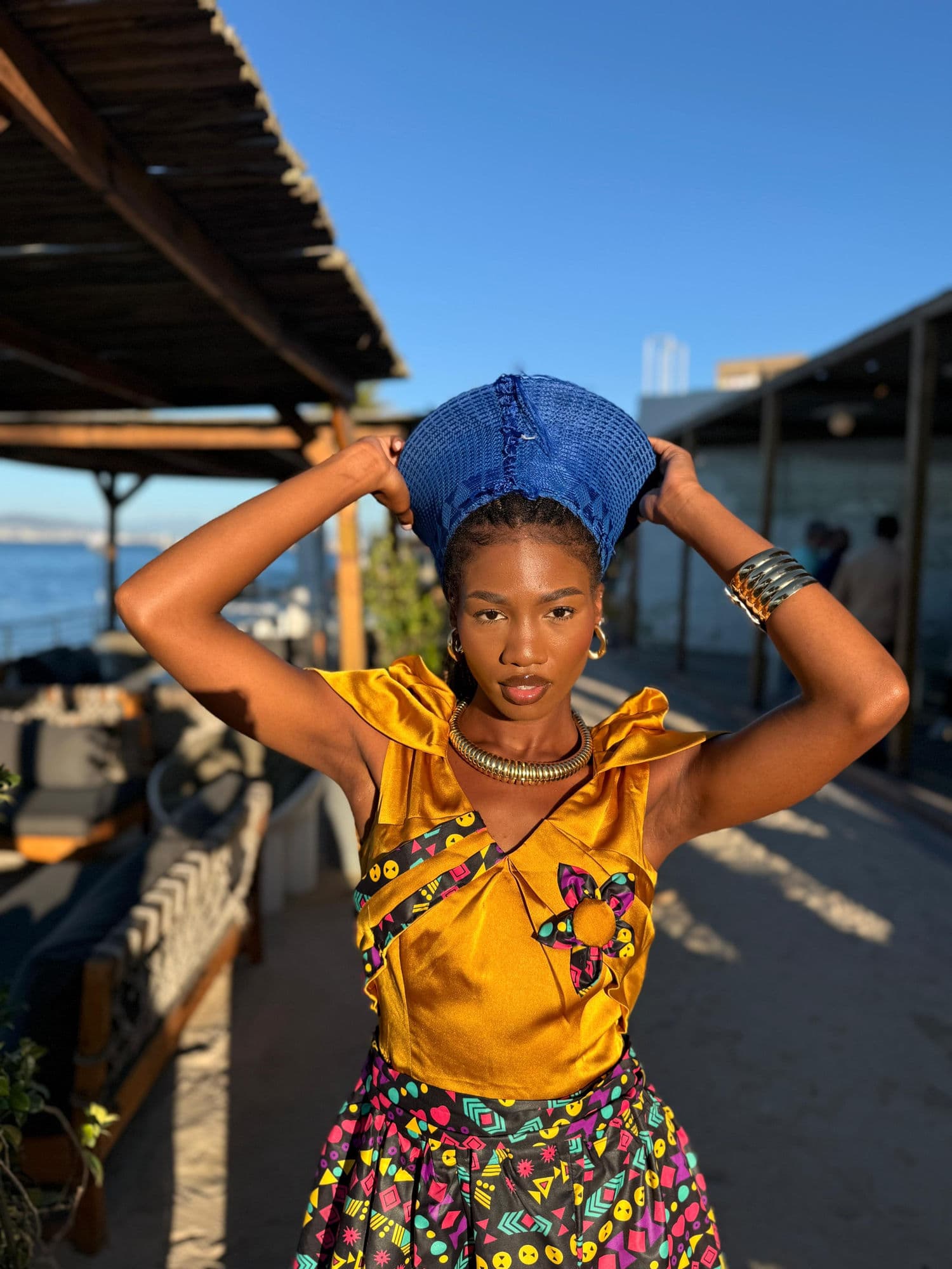 Performer in traditional headwrap at a beach entertainment event
